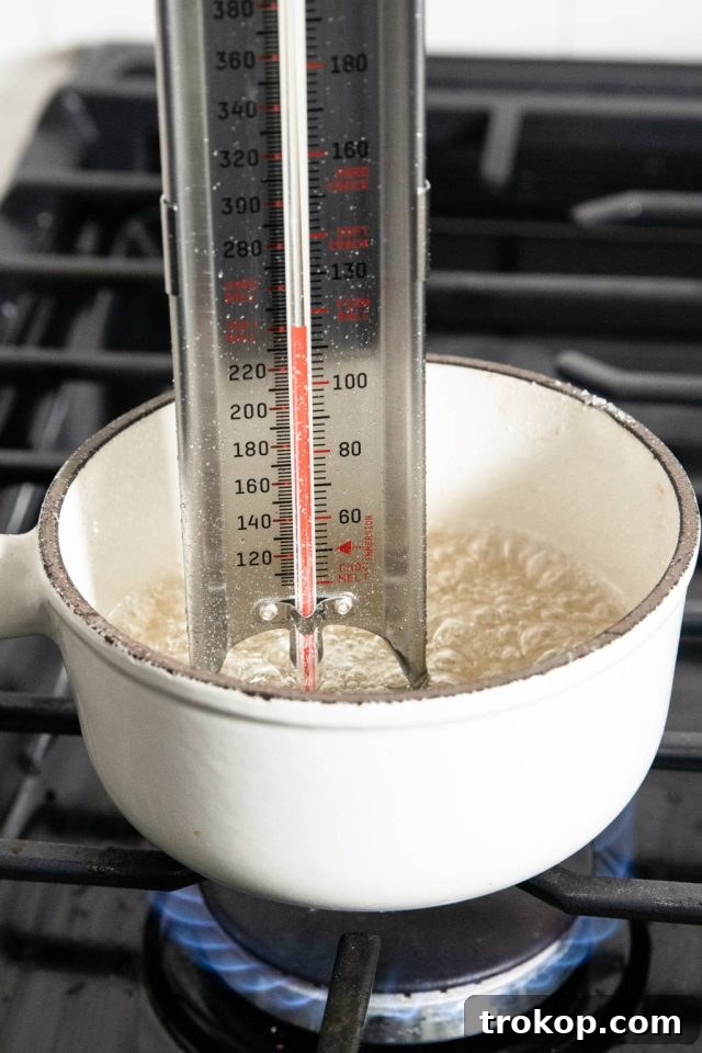 Silky Smooth Italian Meringue Buttercream Frosting 5 Sugar syrup cooking in a small pan, reaching the softball stage (235°-240°F) for Italian Meringue Buttercream.