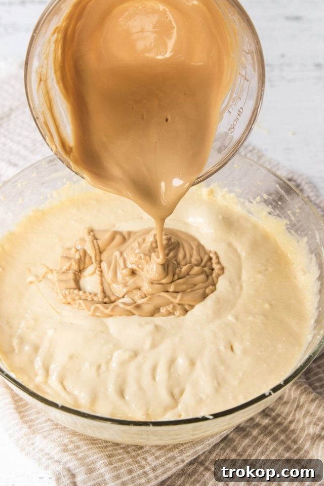 Decadent Baked Caramilk Cheesecake 6 Adding the melted Caramilk chocolate to the cheesecake filling for a unique flavor