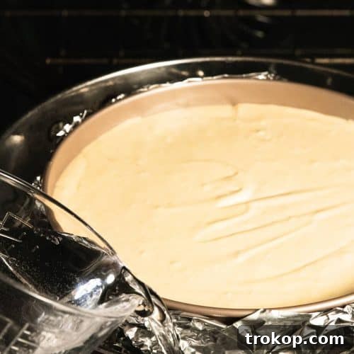 Pouring the hot water in the pan around the cheesecake