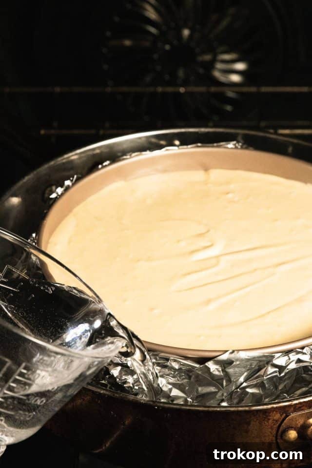 The Ultimate Water Bath for Silky Smooth Cheesecake 8 Pouring the hot water in the pan around the cheesecake