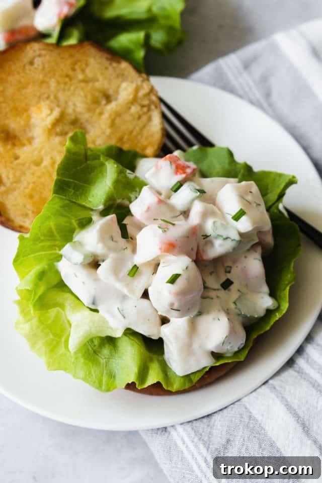 A vibrant bowl of easy crab seafood salad, garnished with fresh dill.