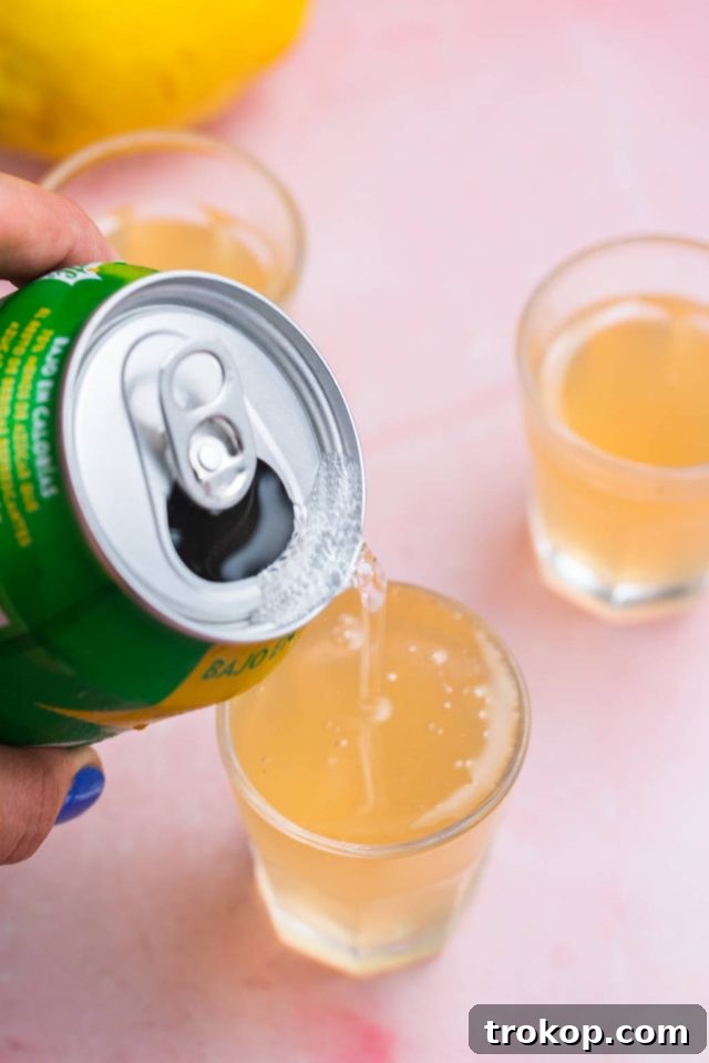 Topping up the Green Tea Shot with lemon-lime soda, adding the final fizz and flavor.