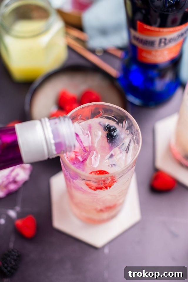 Pouring raspberry vodka into the glass to create layers in the Grateful Dead recipe