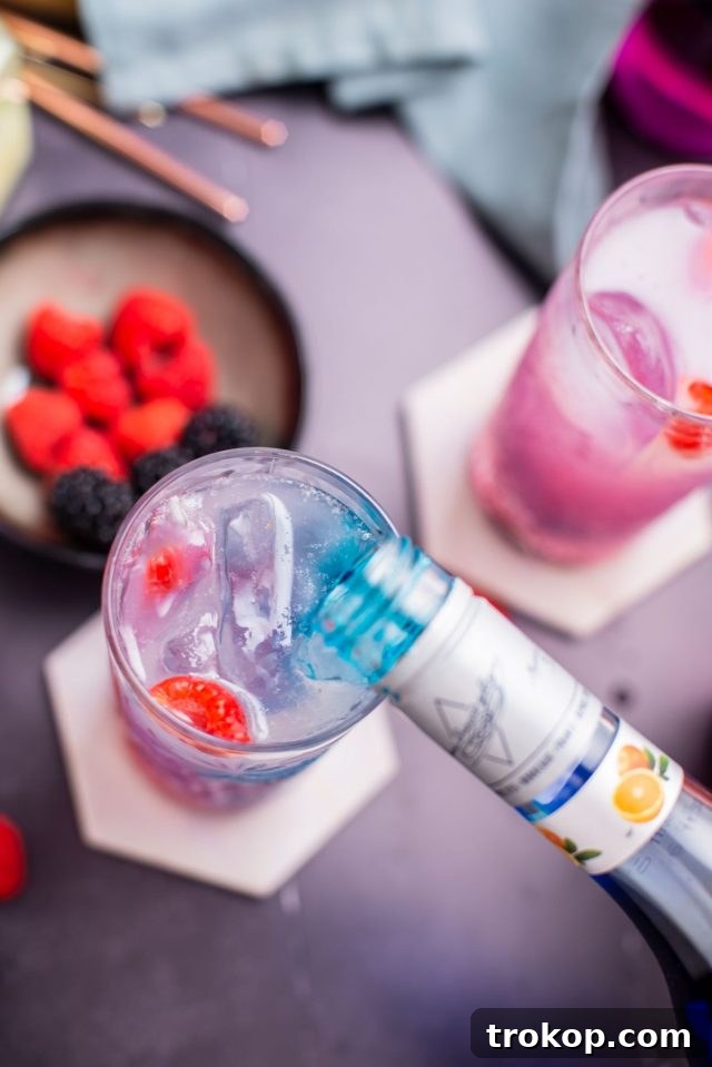 Pouring blue liquor into the glass, completing the Grateful Dead cocktail