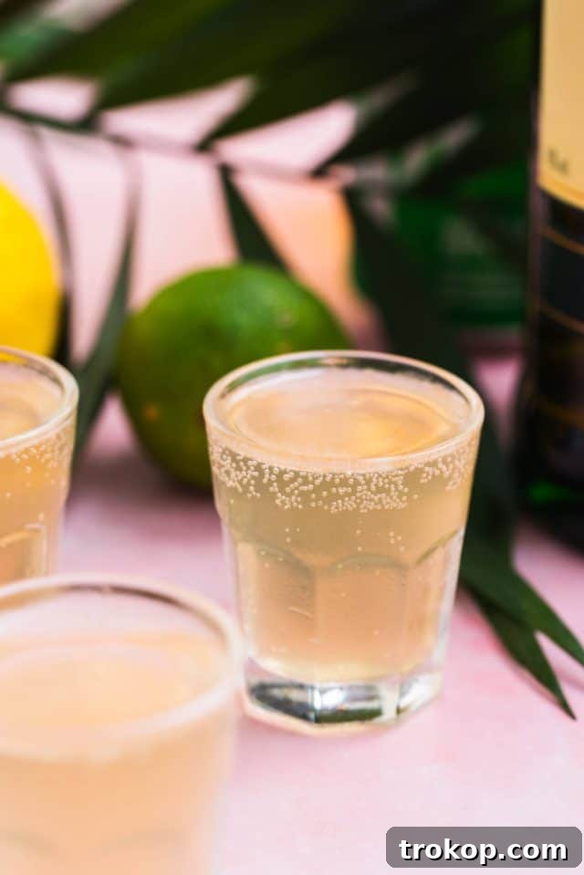 A refreshing Green Tea Shot, appearing a vibrant greenish-gold.