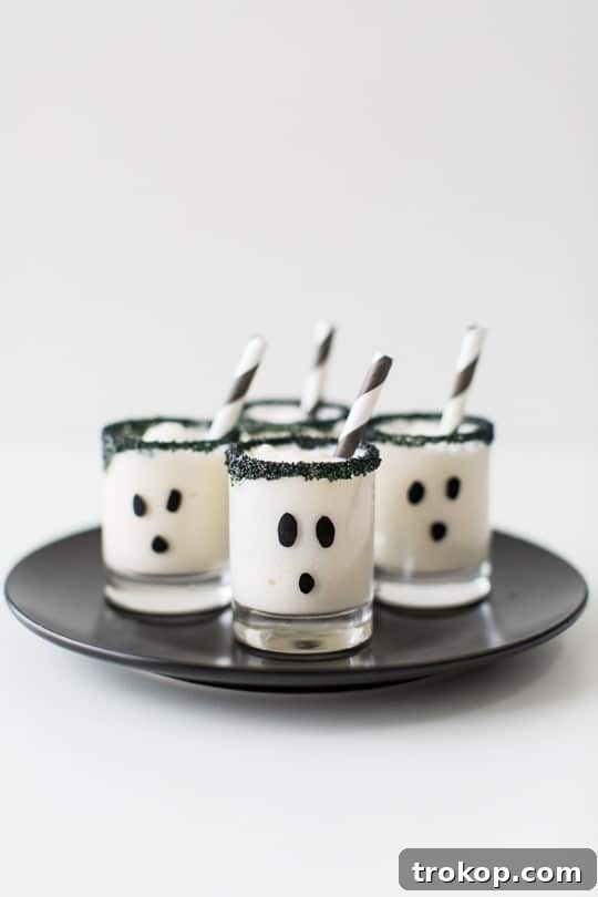 Spooky ghost-themed ice cream cake shots with black sugar rim for Halloween.