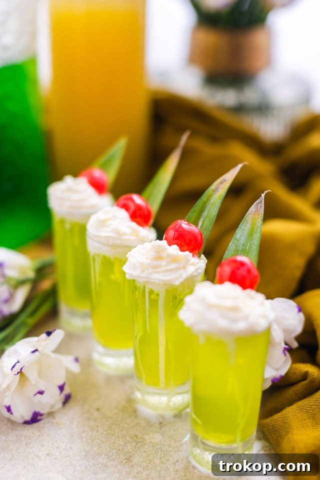 A vibrant green Scooby Snack Shot with a whipped cream topping, perfect for Halloween or Christmas.