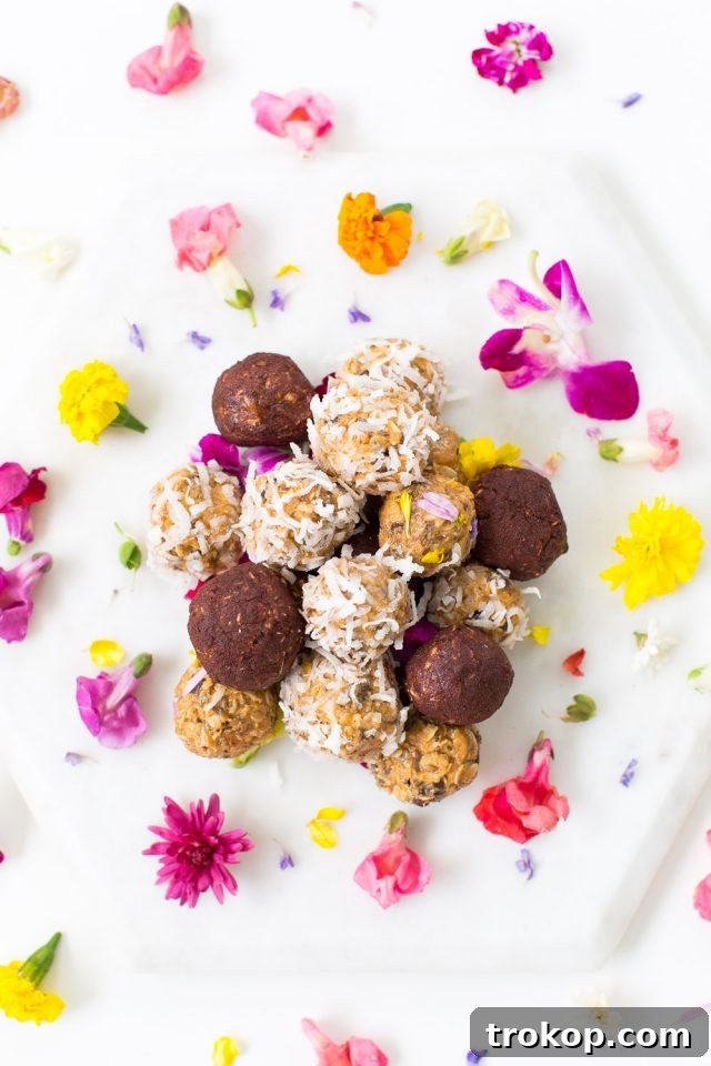 Crave-Worthy Peanut Butter Desserts You Need to Bake 11 Mound of no-bake peanut butter balls surrounded by edible flowers, suggesting a healthy and pretty snack.