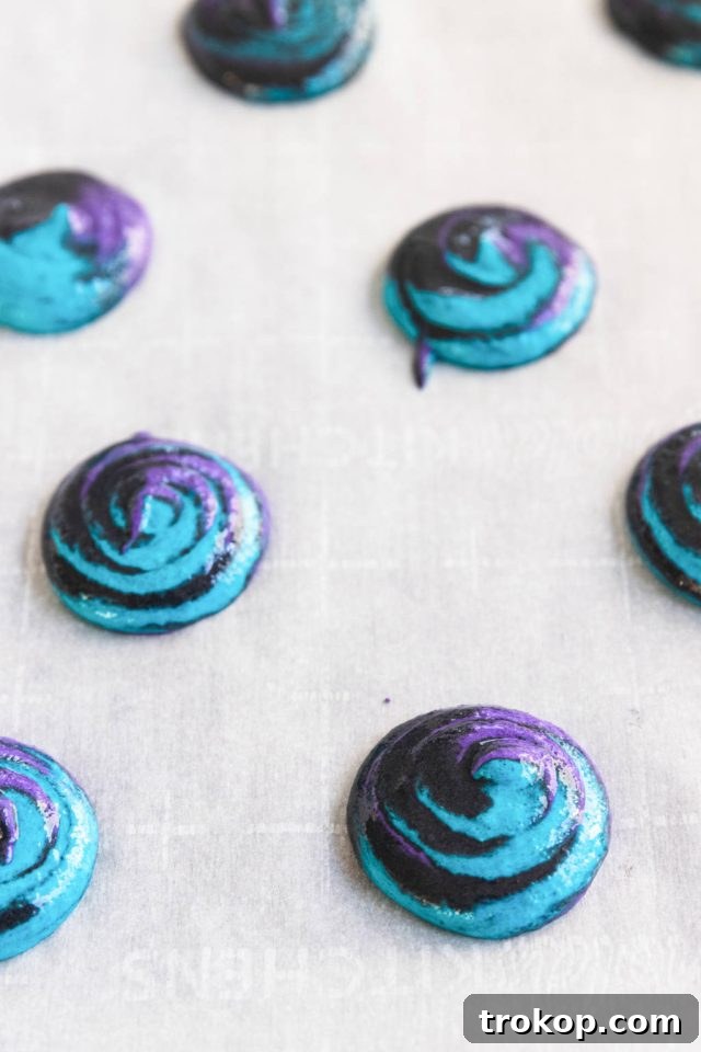 Cosmic Macaron Delights 8 Close-up of freshly piped galaxy macarons on a baking sheet, ready for drying.