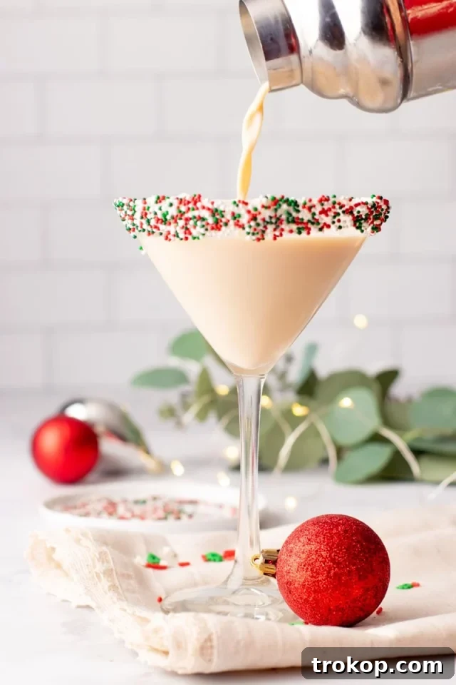 25 Easy & Festive Christmas Cocktails for Holiday Merriment 13 Sugar Cookie Martini for Christmas cocktail recipes, with a festive red and green sprinkle rim.