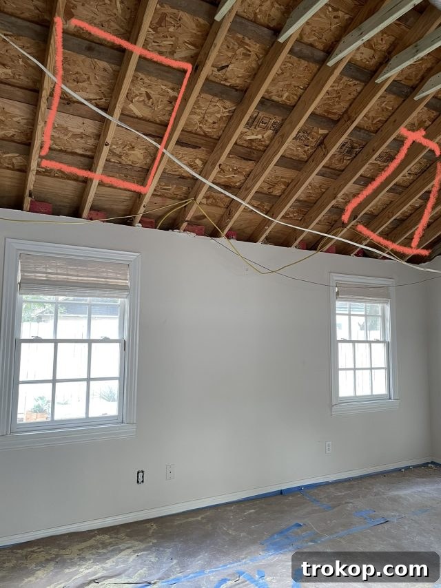 During installation: a glimpse into how skylights are integrated into a bedroom ceiling, showing the framing and opening by Ashley Rose of Sugar & Cloth.