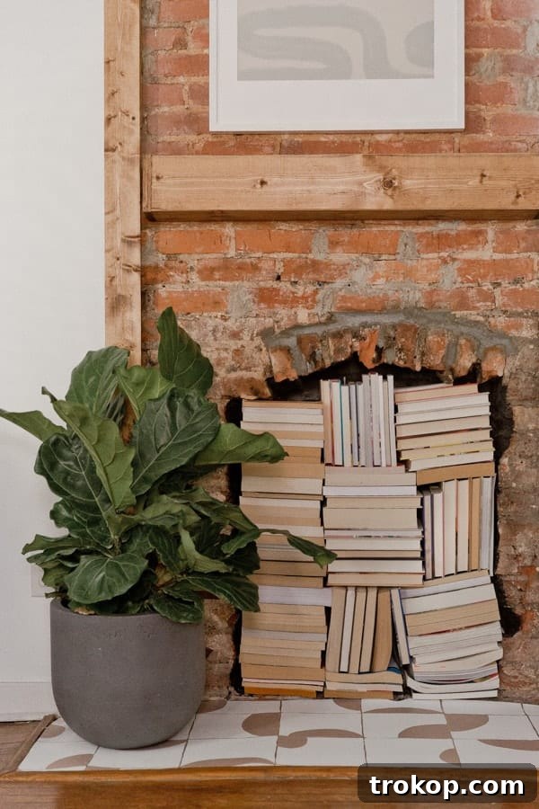 Stack of books inside an empty fireplace, creating a cozy reading nook.