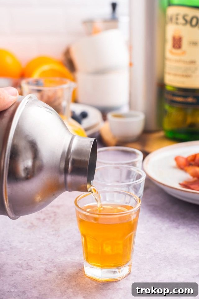 A cocktail shaker being used to mix the ingredients for a Breakfast Shot, before pouring into a glass.