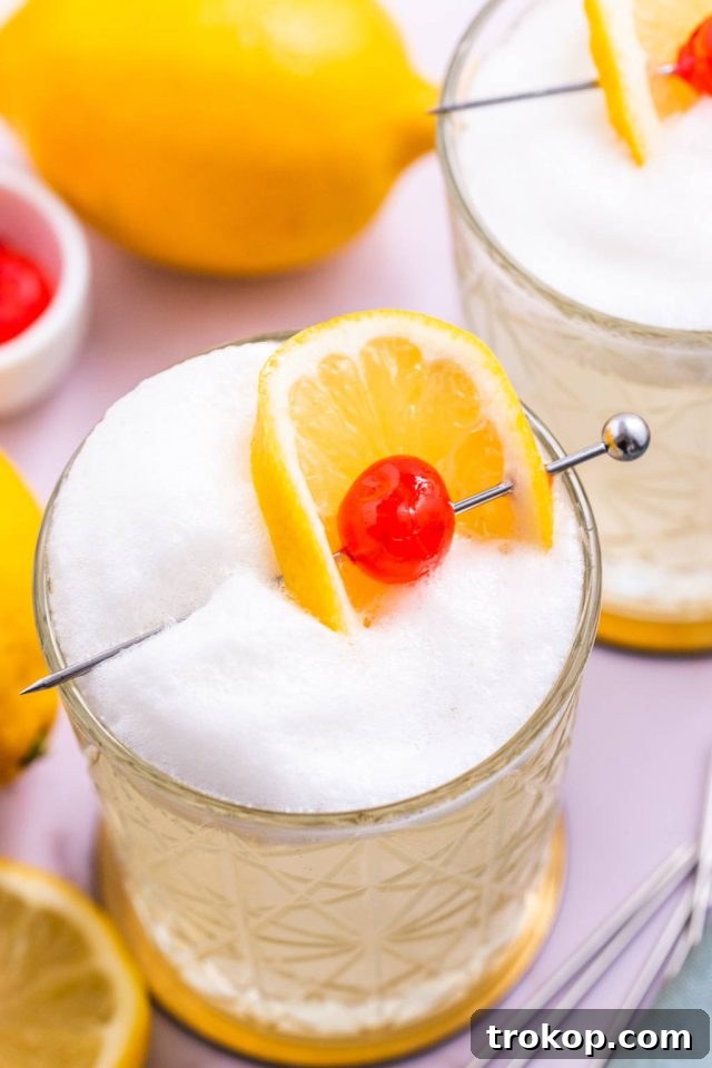 Top view of a garnished Vodka Sour with a lemon wheel and a cocktail cherry on a pick