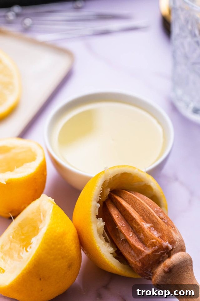Squeezing fresh lemon juice into a glass, an essential step for a Vodka Sour