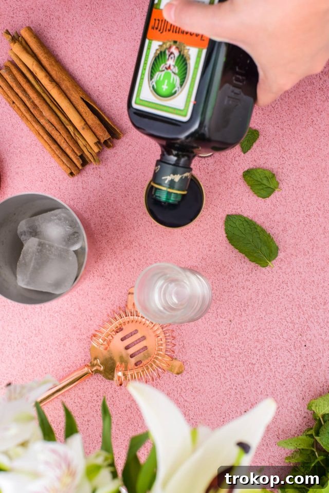 Adding Jagermeister to a jigger for the Liquid Cocaine Shot recipe.