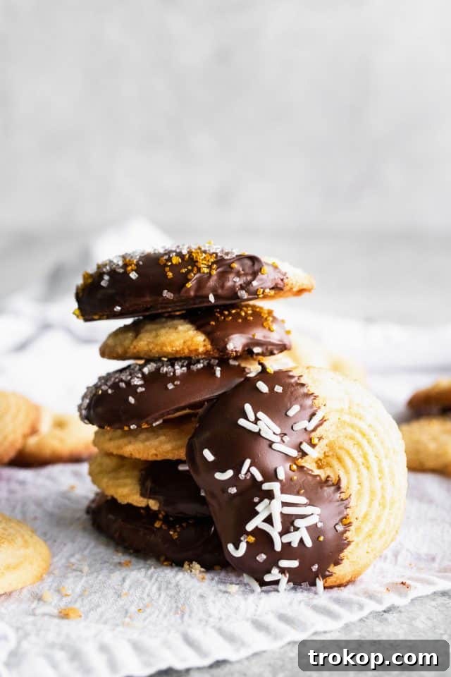 A stack of delicious easy butter cookies with chocolate drizzle and colorful sprinkles, ready for a cookie box.