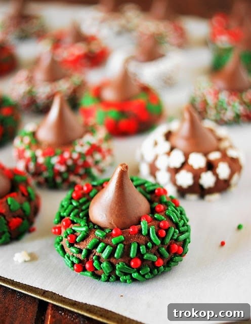 Holiday Cookie Masterclass: Recipes for Delicious Treats and Stunning Displays 20 Classic Christmas Chocolate Kiss Cookies, featuring soft peanut butter cookies topped with Hershey's Kisses and festive sprinkles.