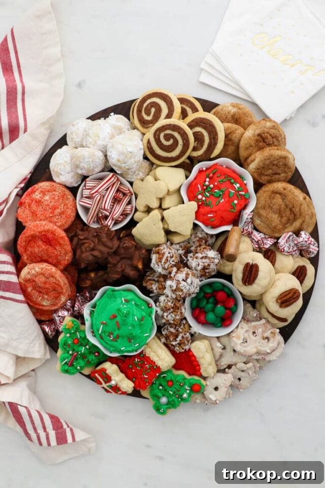 Holiday Cookie Masterclass: Recipes for Delicious Treats and Stunning Displays 3 An elaborate Christmas Cookie Dessert Charcuterie Board featuring a variety of cookies, candies, and small bowls of dips, all artfully arranged.