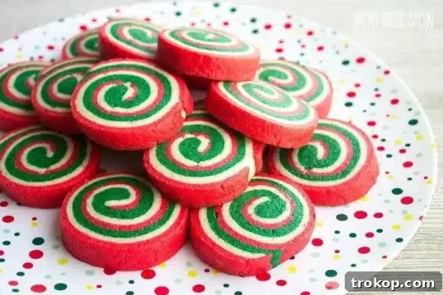 Holiday Cookie Masterclass: Recipes for Delicious Treats and Stunning Displays 30 Vibrant Christmas Pinwheel Cookies, showcasing spiraled red and green cookie dough for a festive look.