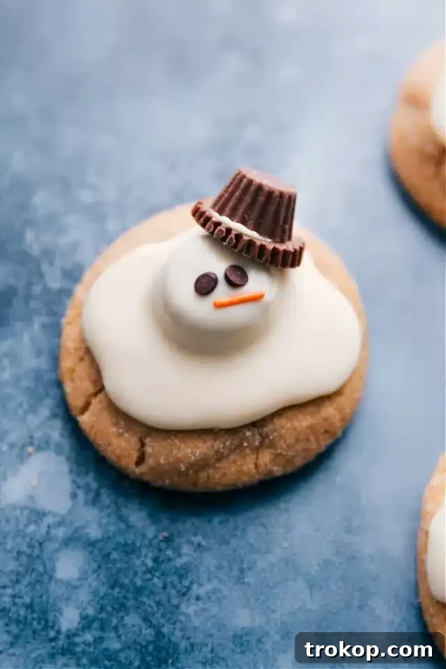 Holiday Cookie Masterclass: Recipes for Delicious Treats and Stunning Displays 31 Humorous Melted Snowmen Cookies, featuring peanut butter cookies topped with melted white chocolate and decorated to resemble a melting snowman.