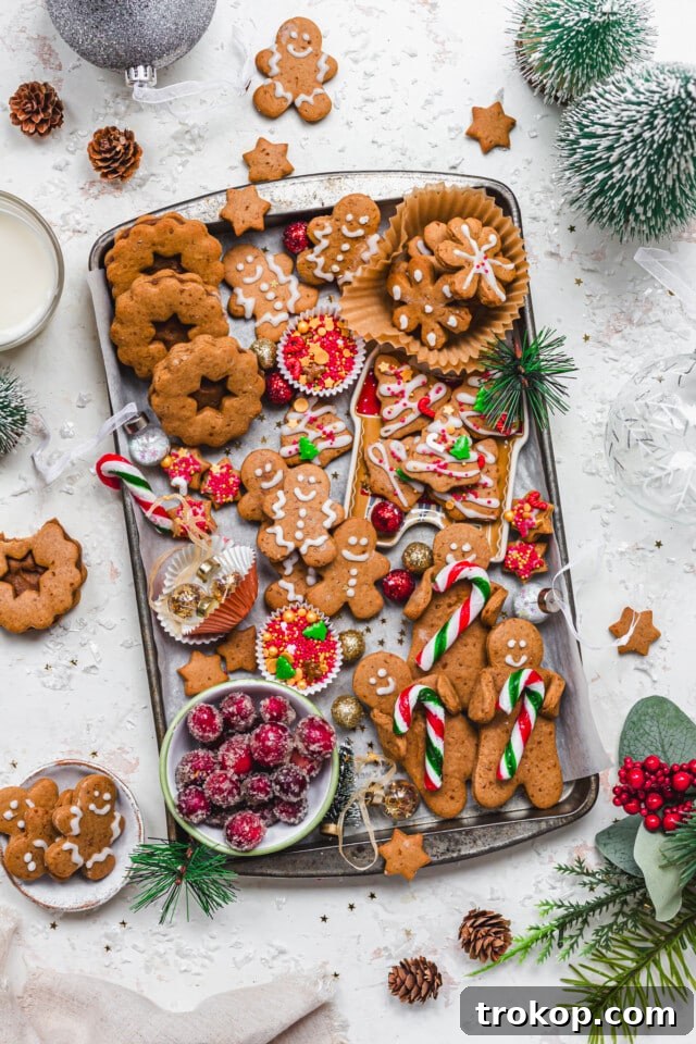 Holiday Cookie Masterclass: Recipes for Delicious Treats and Stunning Displays 5 An inviting Vegan Gingerbread Cookie Tray displaying a variety of gingerbread cookies, some filled with chestnut butter, presented casually on a baking tray.