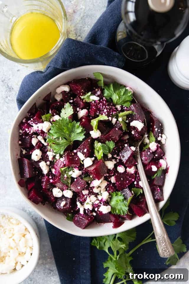 Vibrant beetroot salad with creamy goat cheese, parsley, and a lemon vinaigrette dressing.