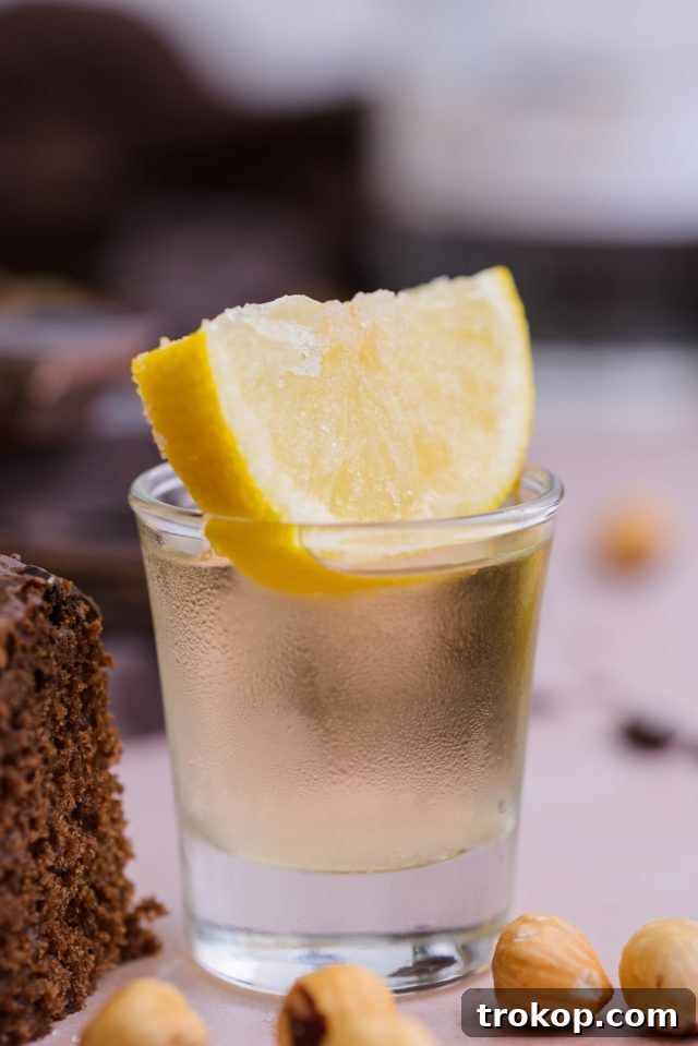 Close-up shot of a glass of Chocolate Cake Shot, highlighting its amber color and elegant presentation