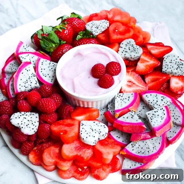 Brilliant Fruit Platter Ideas and Expert Presentation Tips 13 A charming heart-themed Valentine's Day fruit platter featuring an arrangement of pink, red, and white fruits with a delicious vegan fruit dip.