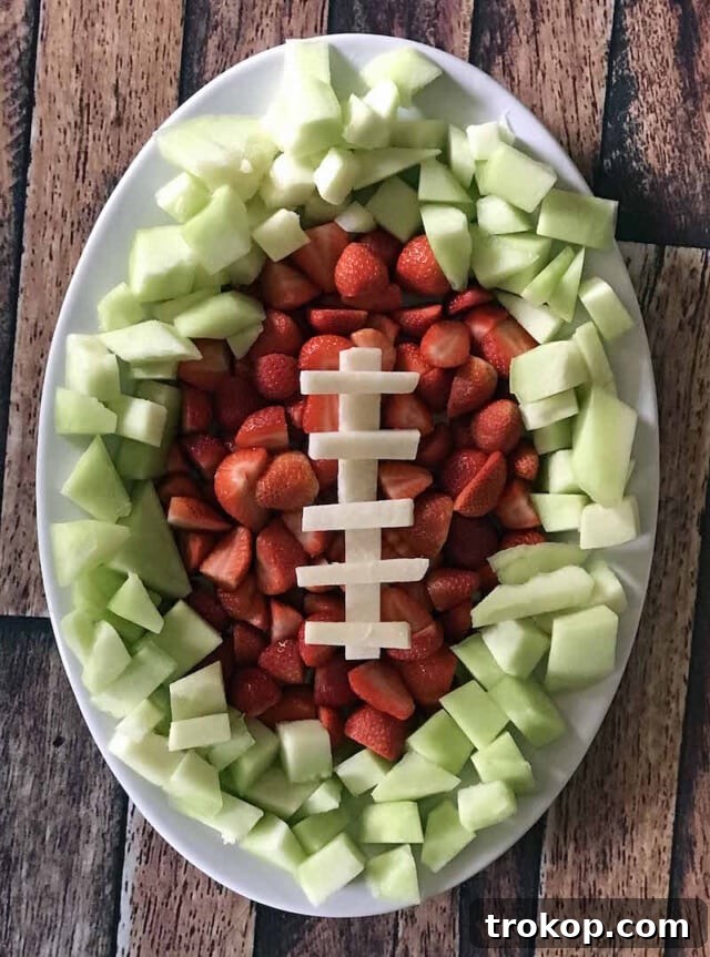 Brilliant Fruit Platter Ideas and Expert Presentation Tips 18 A festive game day football fruit tray with sliced honeydew as the field, strawberries for end zones, and jicama laces, perfect for a watch party.