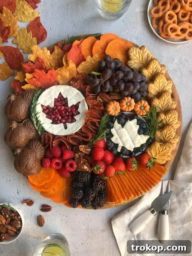 Brilliant Fruit Platter Ideas and Expert Presentation Tips 23 A beautiful Thanksgiving fall fruit board featuring creamy baked brie topped with a festive leaf cutout, surrounded by figs, pears, apples, and grapes, embodying the rich colors of autumn.