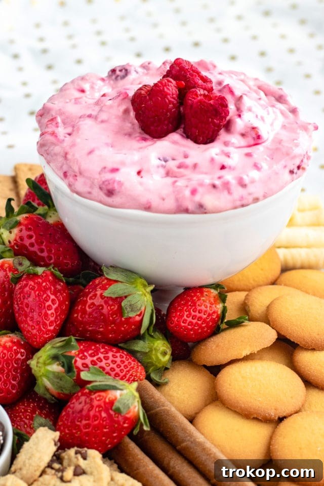 Brilliant Fruit Platter Ideas and Expert Presentation Tips 28 A close-up of a creamy raspberry cream cheese dip in a white bowl, ready for dipping fresh fruits, showcasing its rich texture.