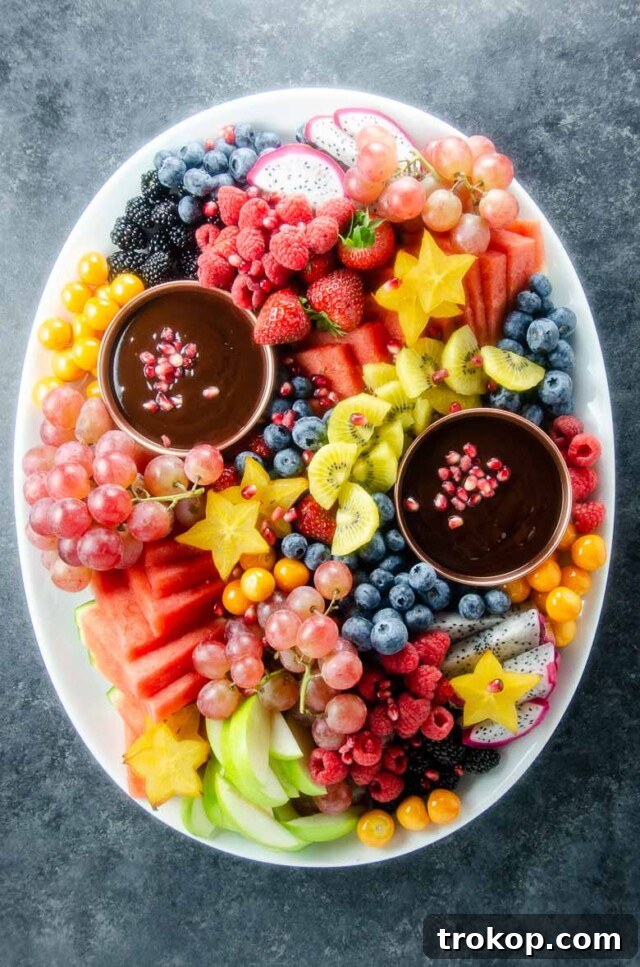 Brilliant Fruit Platter Ideas and Expert Presentation Tips 5 A vibrant fruit platter featuring an assortment of fruits like strawberries, grapes, and melon slices, centered around a rich, homemade dark chocolate ganache dip.