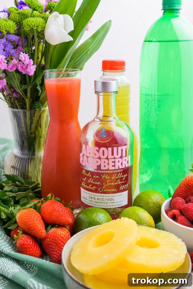 Spring Celebration Punch 4 Fresh ingredients laid out, including raspberries, pineapple, strawberries, and lime, essential for making the flavorful Easter Punch by Ashley Rose of Sugar & Cloth.