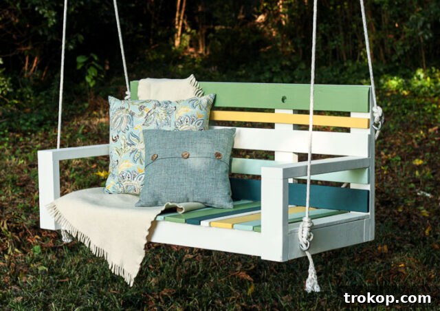 DIY striped porch swing built from pallet wood and Krazy Glue, featuring a detailed tutorial for an affordable and charming outdoor project