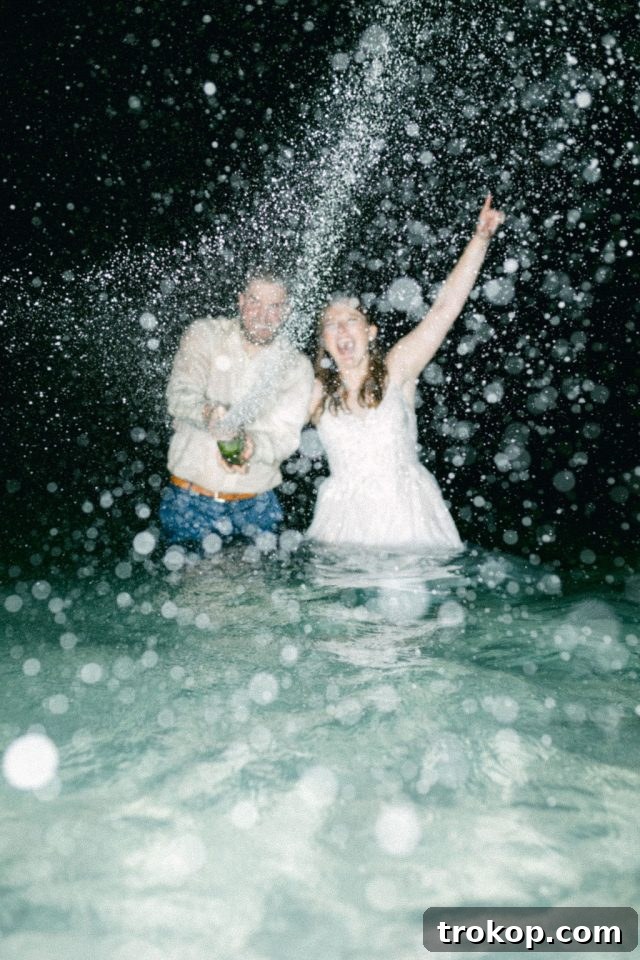 Beaches Turks and Caicos Sunset Vows by the Sea 56 The bride and groom enjoying a celebratory champagne moment in the ocean after their wedding