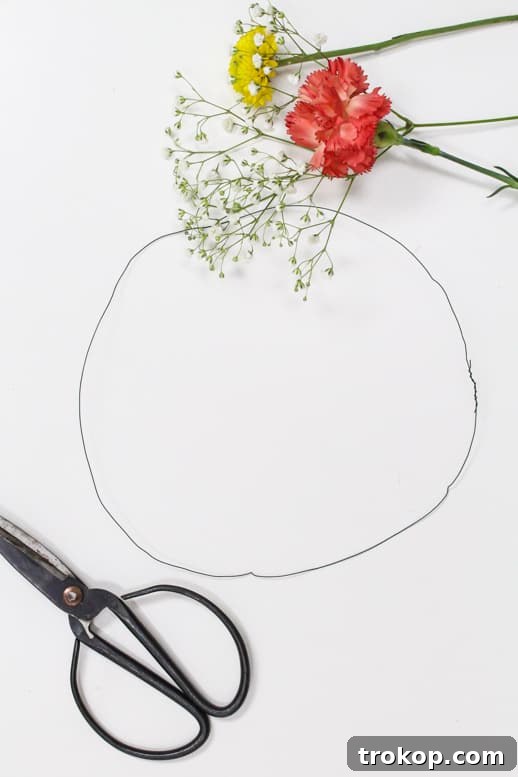 Assortment of floral wires, cutters, pliers and various fresh flowers for DIY floral headpiece creation
