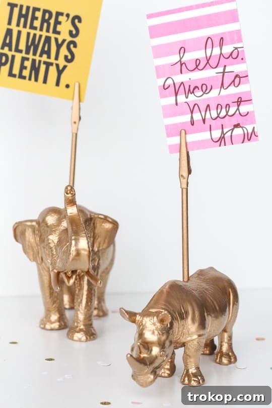 Arrangement of materials needed for DIY animal memo holders, including a plastic animal, dowel rod, alligator clip, super glue, and spray paints.
