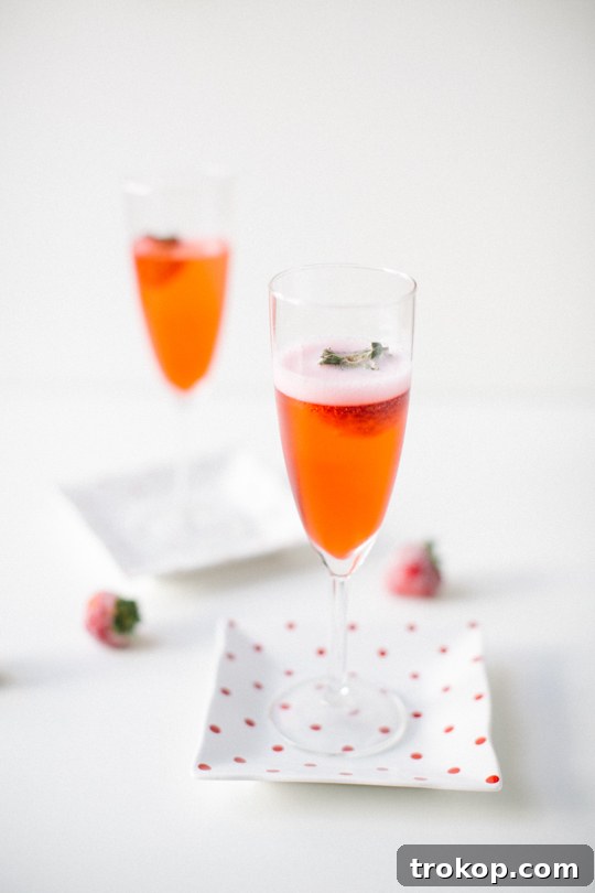 Elegant Red Currant Champagne Cocktail with Frozen Strawberry Garnish