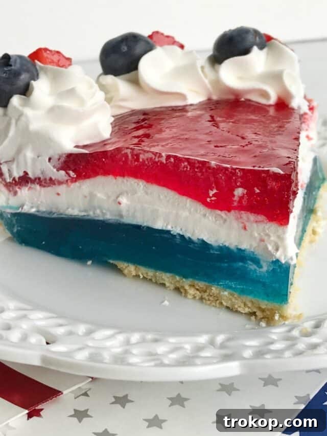 A slice of layered patriotic jello pie with red, white, and blue colors