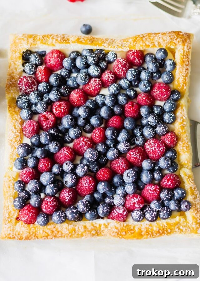 Elegant red, white, and blue berry tart with fresh fruit