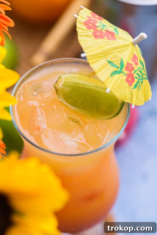 Sunshine in a Glass Bahama Mama Recipe 3 Close-up of a Bahama Mama garnished with a lime wedge and a miniature cocktail umbrella, ready to be enjoyed.