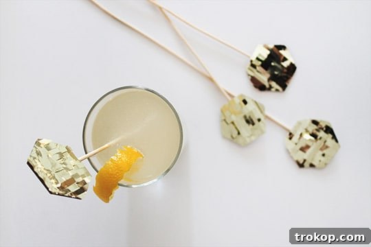 A French 75 cocktail garnished with a DIY gold fringe stirrer.