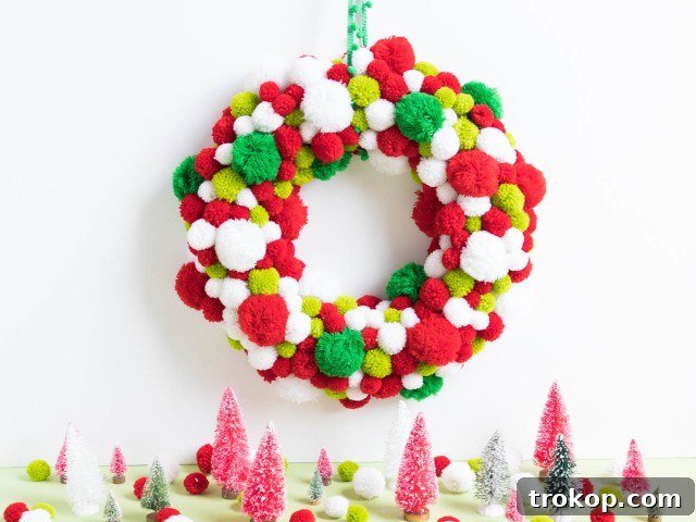 27 Handmade Christmas Wreaths for a Festive Home 25 Playful DIY Pom Pom Christmas Wreath with assorted colors and sizes
