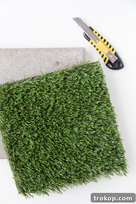 Box cutter next to a paver stone with turf for cutting