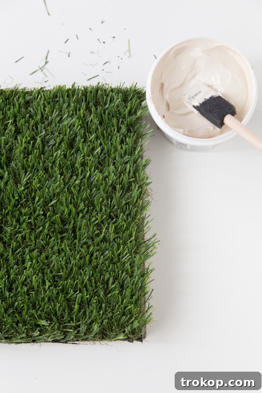 Hand pressing turf onto a paver stone
